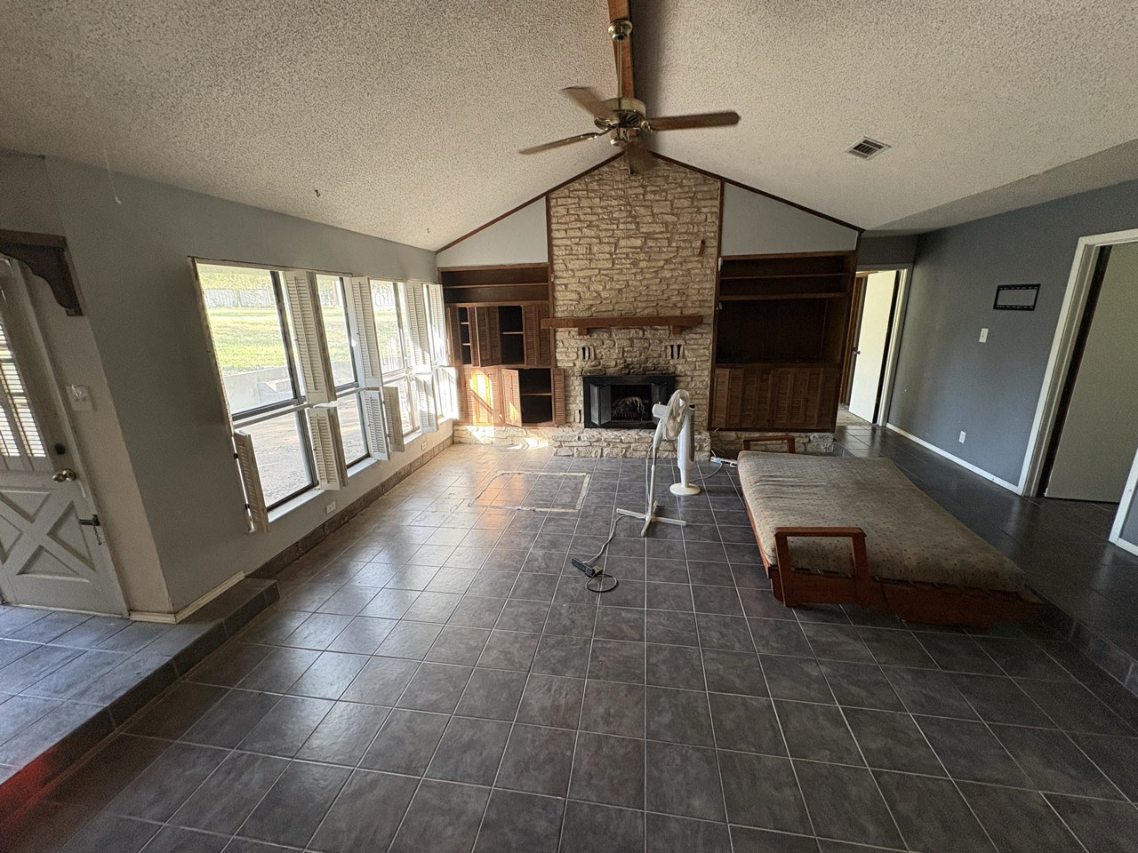 Living room with vaulted ceiling and stone fireplace in the Dallas home